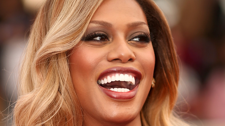 Laverne Cox laughing in red lipstick
