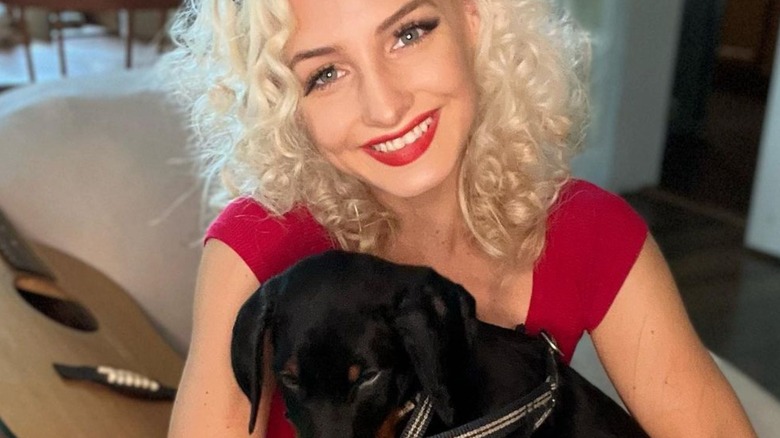 Moriah Plath poses with a dog