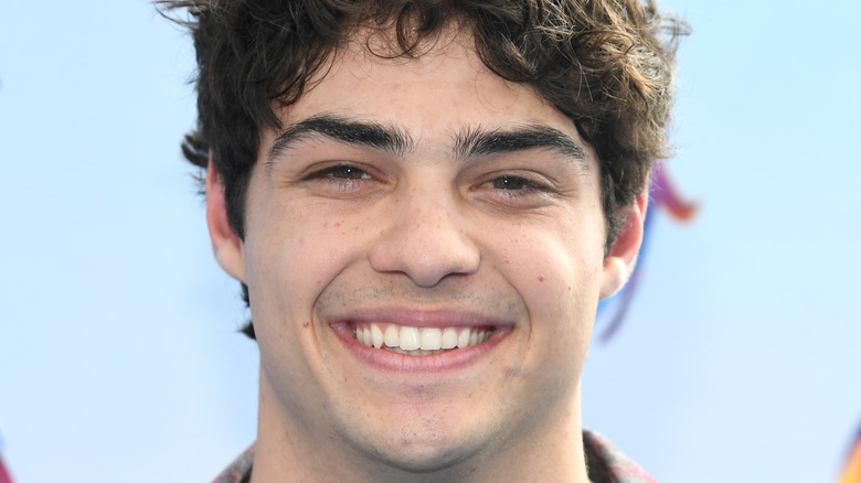 Noah Centineo smiles on the red carpet.