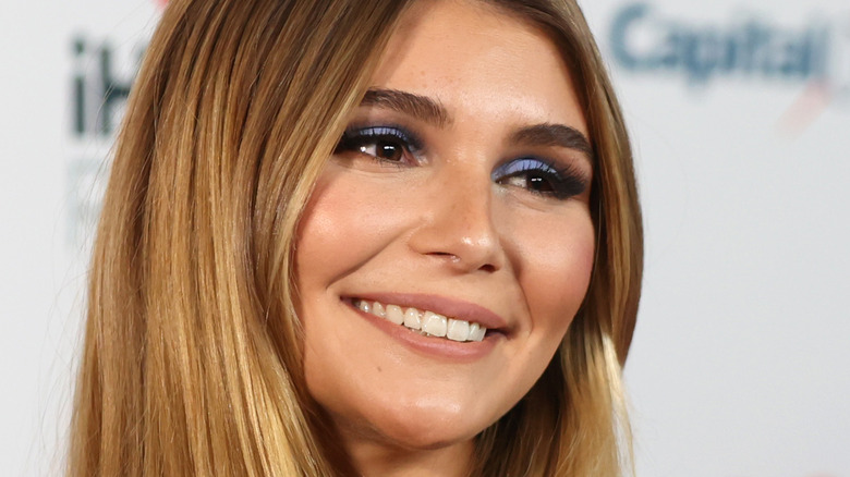 Olivia Jade smiling with blue smoky eyeshadow