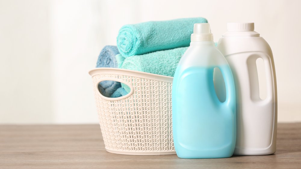 two bottles of laundry detergent and folded towels