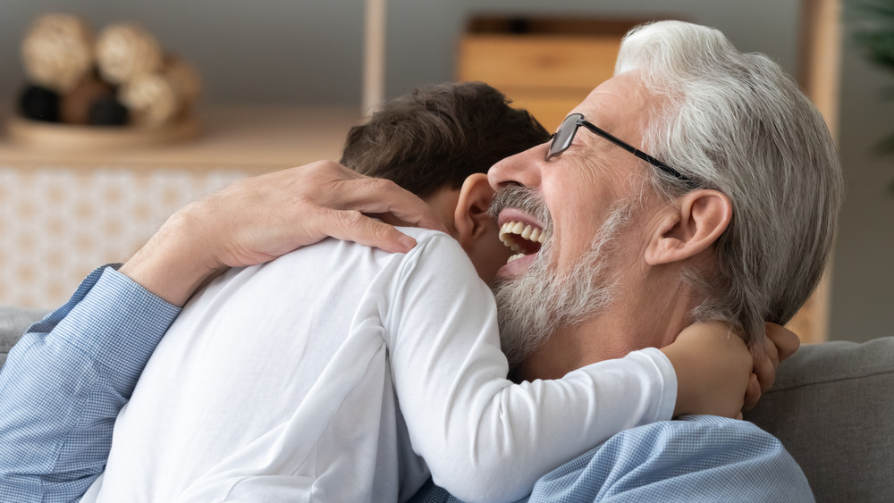 grandfather hugging grandson