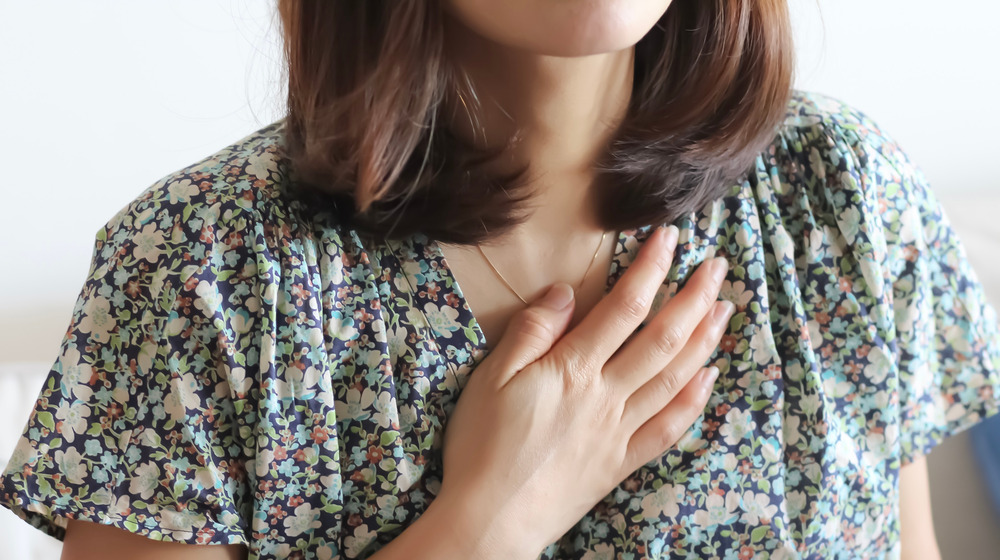 Woman with hand over chest