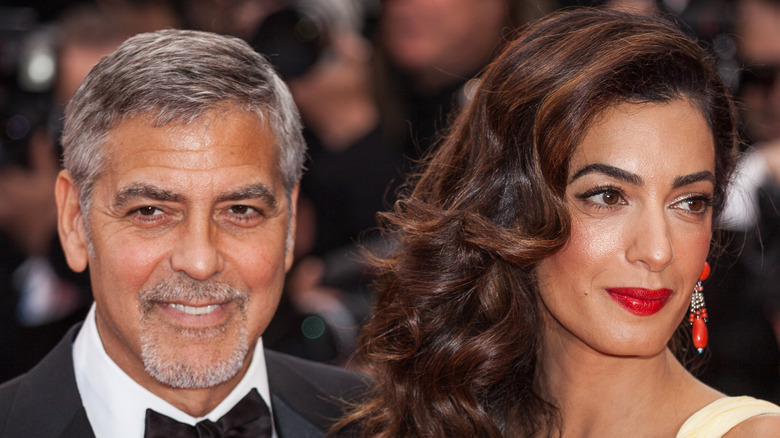 George Clooney and Amal Clooney posing with smiles