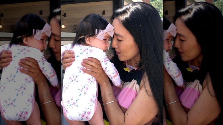 Michelle Kwan holding her baby and smiling