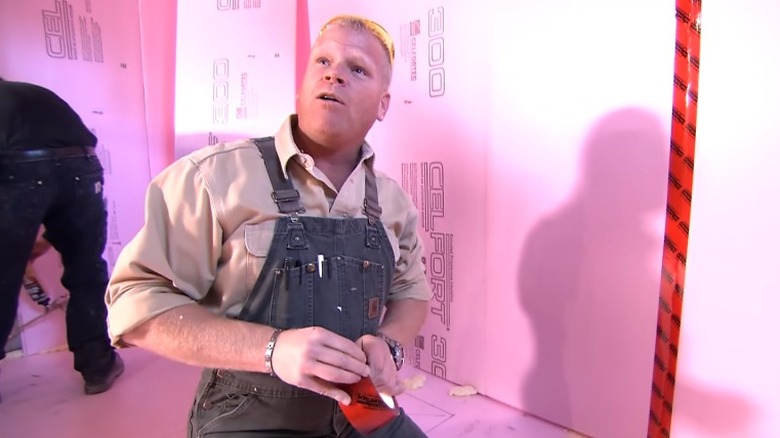 Mike Holmes looking up and talking on construction site