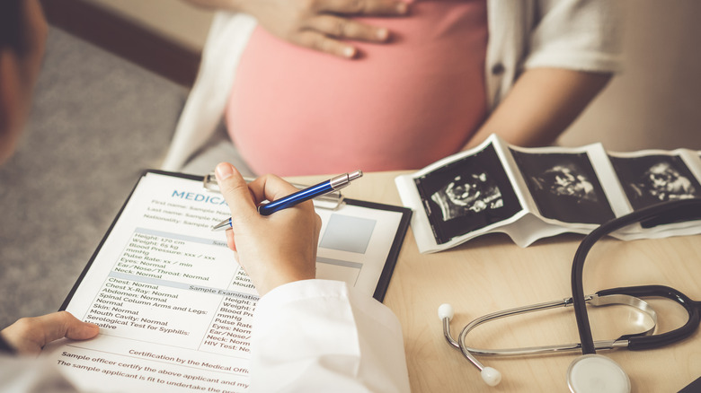 Pregnant woman visits gynecologist at hospital for prenatal care. 