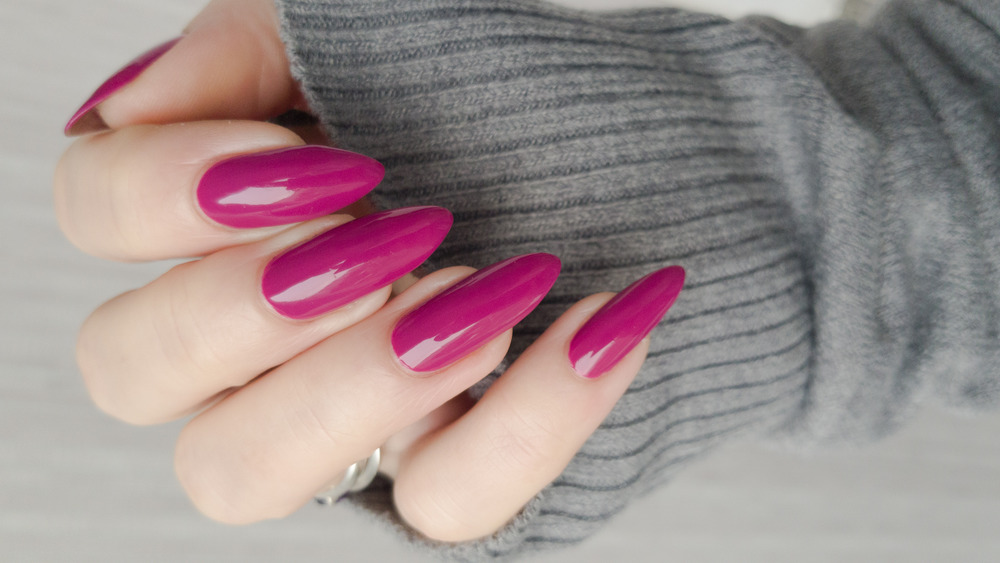 Woman's hand with long pink nails 