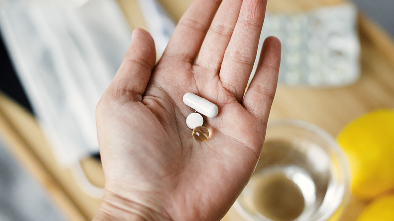 Person holding daily vitamin pills