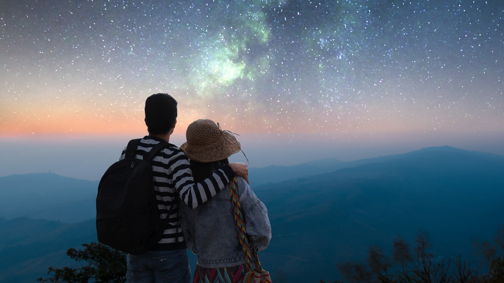 Traveling couple looks out at the stars together