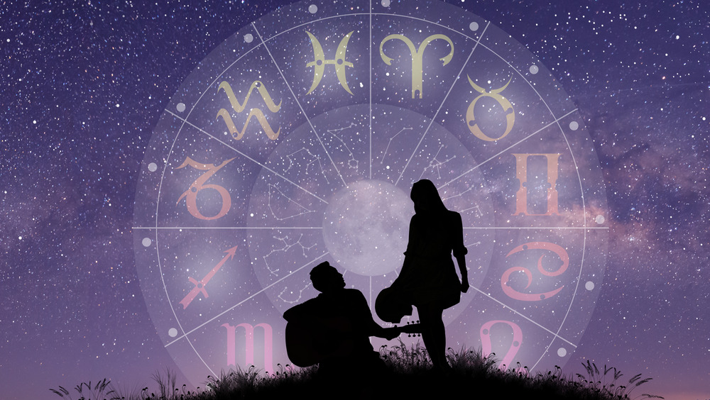 couple under a sky full of stars with zodiac signs