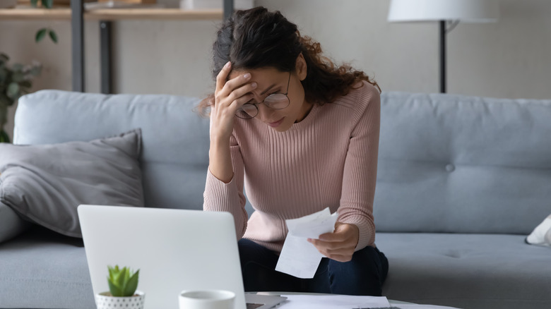 Unhappy woman looking at receipts