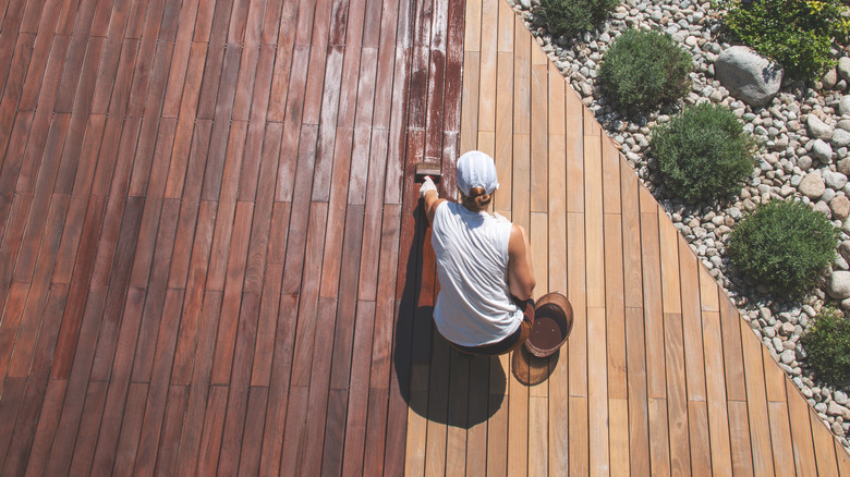 Person staining a deck 