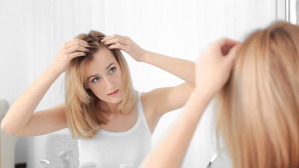 woman examining hairline