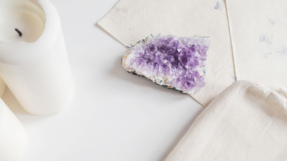Amethyst cluster, a white candle 