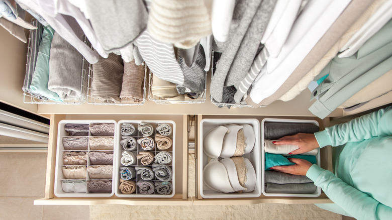 Bird's-eye view of closet drawers with well-organized clothing inside, neutral colors