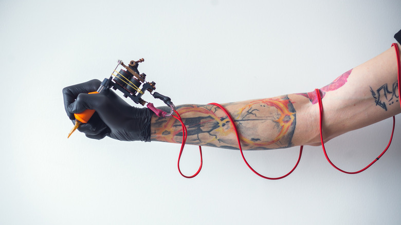 Tattooed arm with needle 