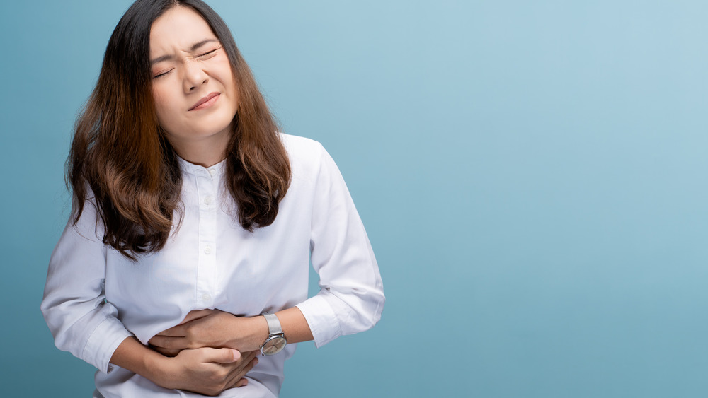 Woman with painful cramps clutching stomach