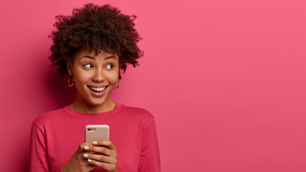 Girl with curly hair holding phone