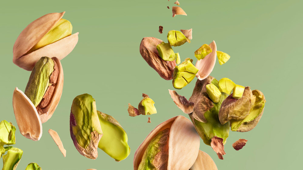 pistachios in there shell with a green background 