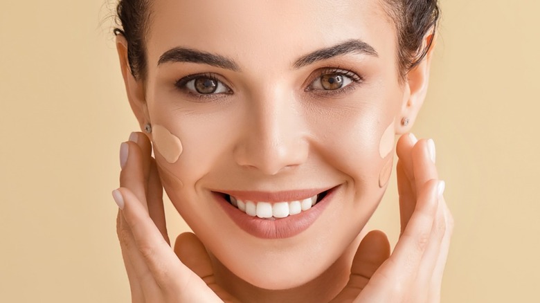 Woman smiling with different shades on foundation on both cheeks