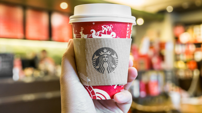hand holding Starbucks holiday cup