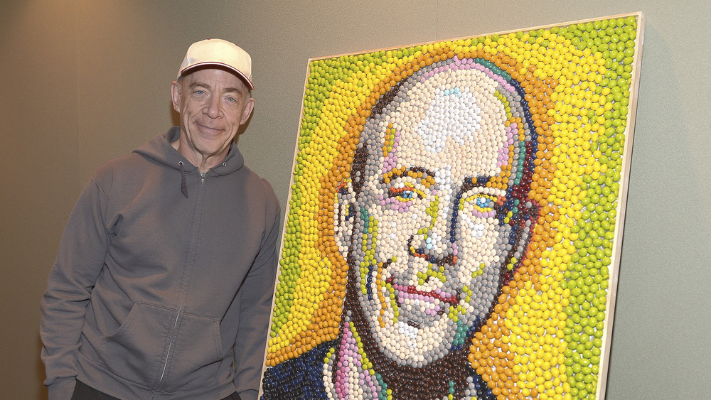 J.K. Simmons posing with an M&Ms portrait of his face