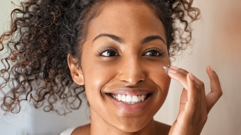 Woman appllying moisturizer to her face