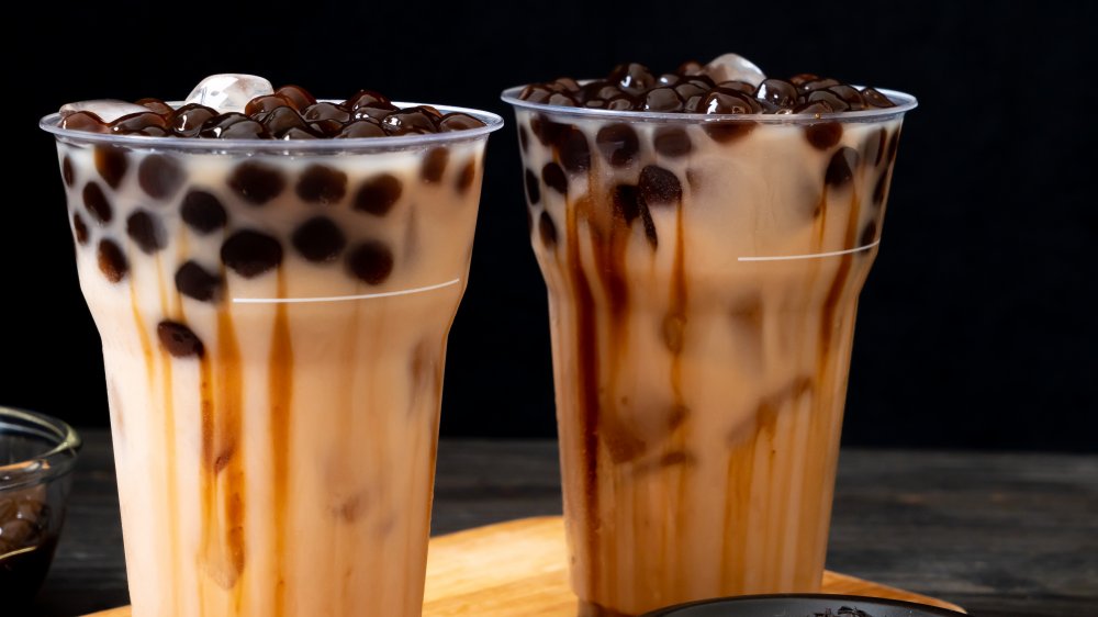 Two cups of bubble tea with syrup added