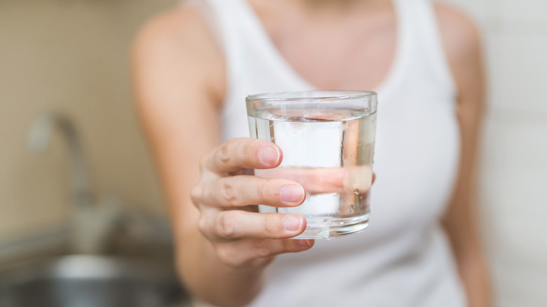 Woman holding glass of water