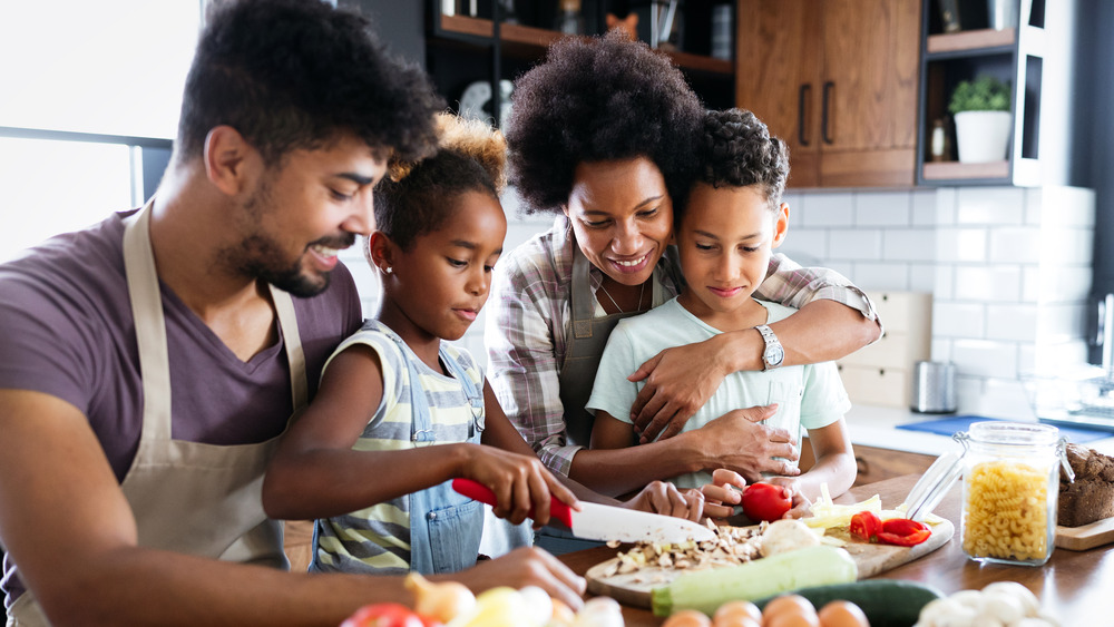 Mom and dad cooking a meal with their daughter and son