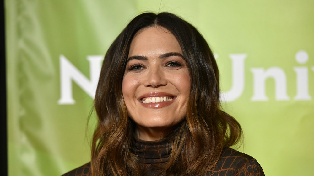 Mandy Moore smiling with green background