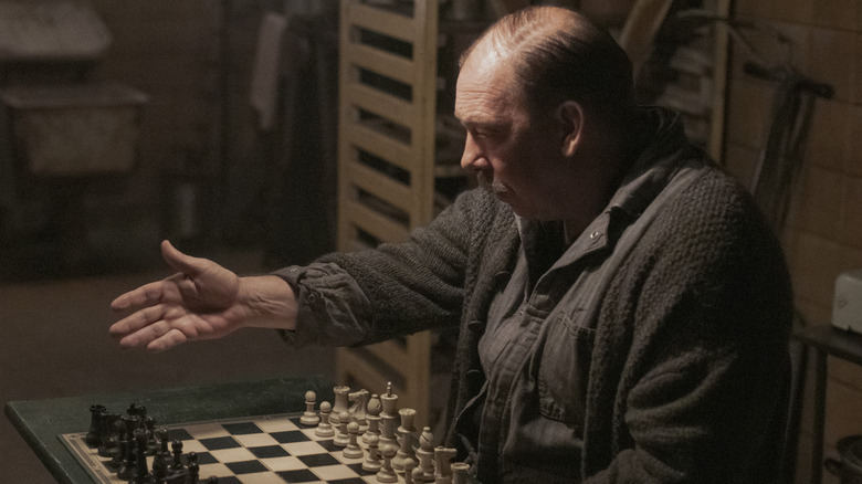 Bill Camp gesturing to a chessboard on The Queen's Gambit