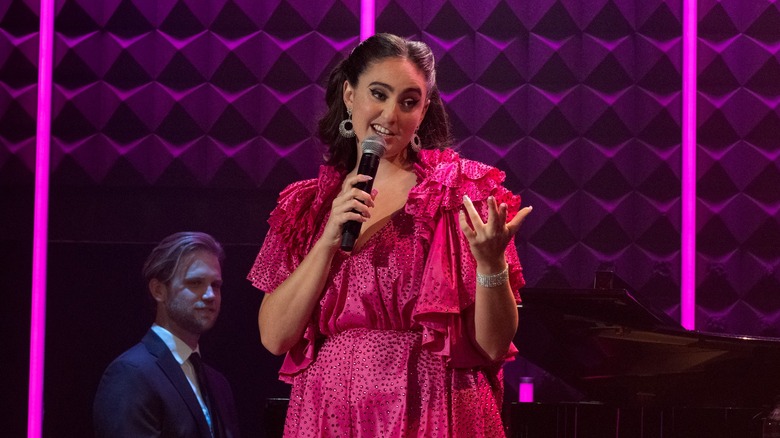 Catherine Cohen in a pink romper onstage in The Twist? She's Gorgeous