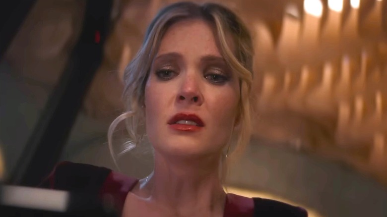 Meghann Fahy staring down at her cell phone in fear in Drop