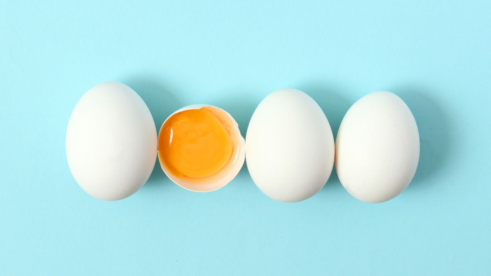 three whole eggs and one egg cracked open