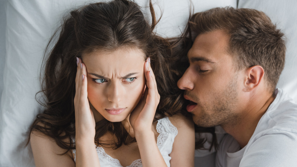 Frustrated woman and sleeping man