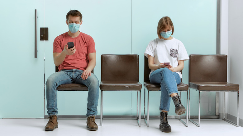 Man and woman in waiting room with masks on