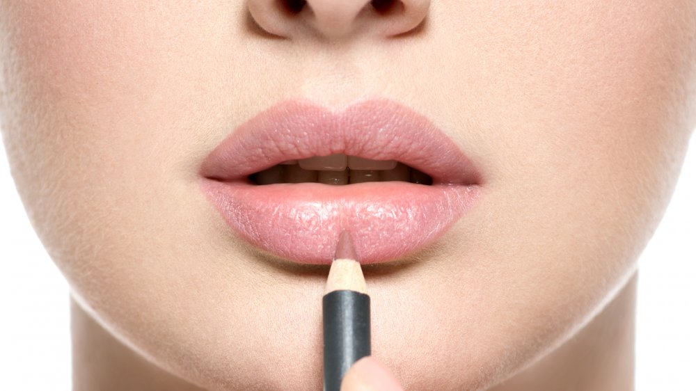 Lip pencil being apploed to lips 