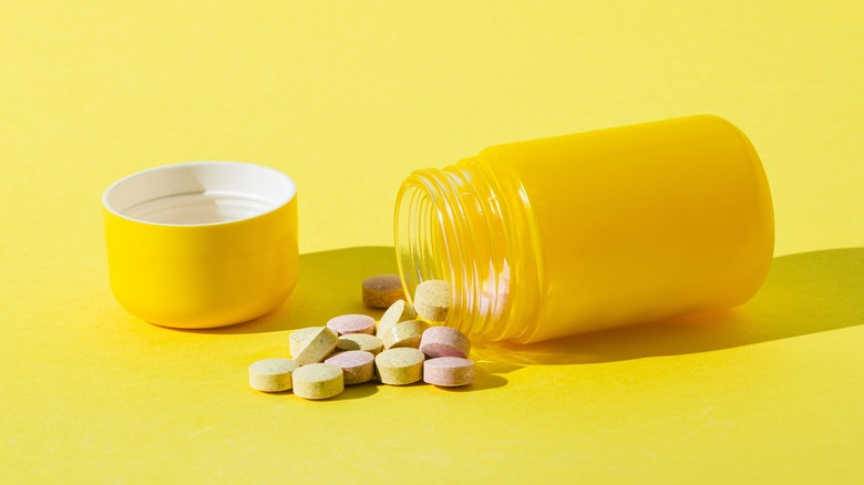Yellow bottle with vitamin pills