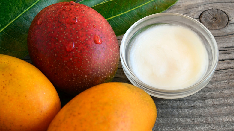 Mango butter with mangoes next to it