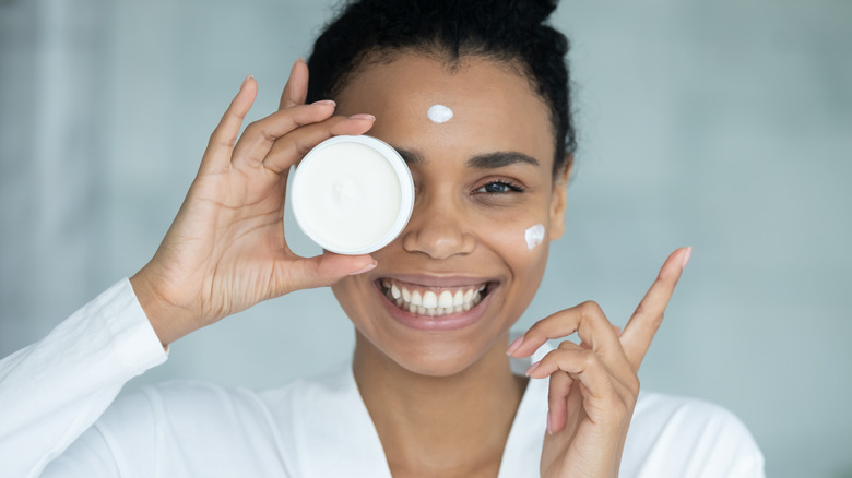 woman applying cream to face