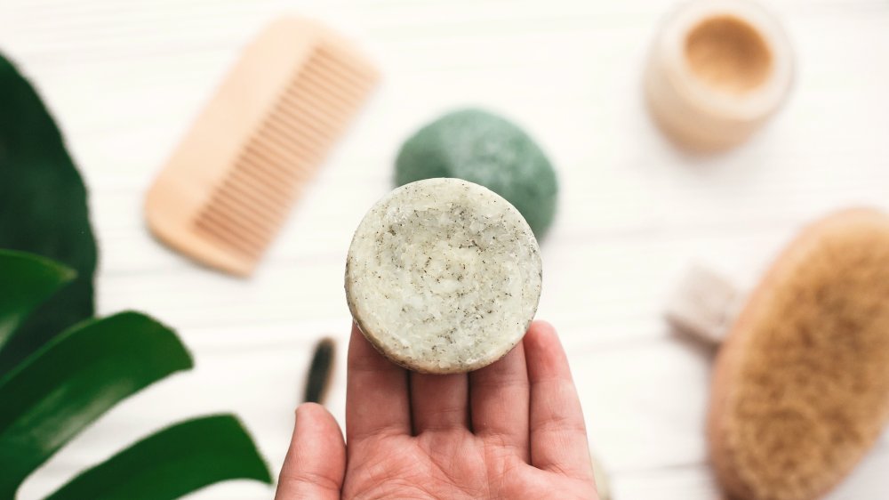 Woman holding solid shampoo bar