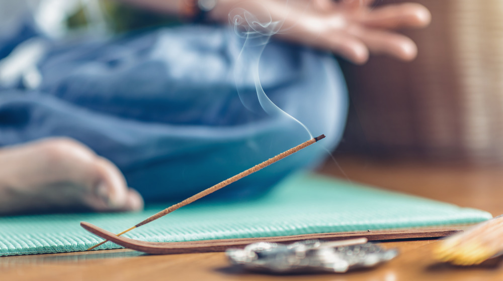 Person meditating with incense