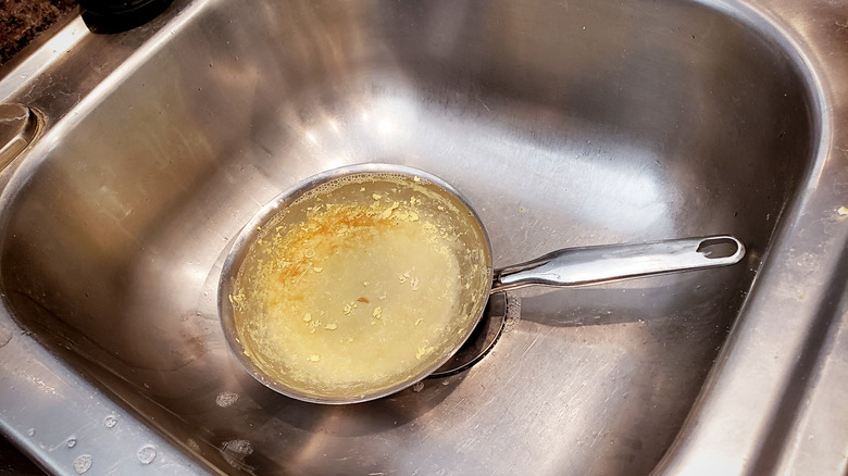 a dirty pan soaking in a sink 