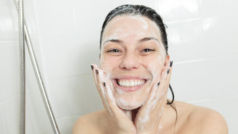 Woman washing face in shower