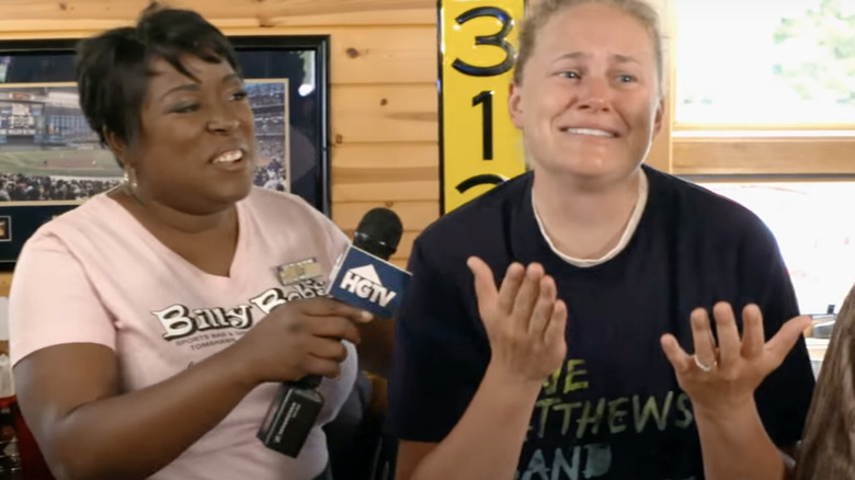 Woman holds HGTV mic to crying woman