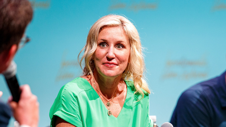 Jenny Marrs in a green dress, looking at someone with a microphone