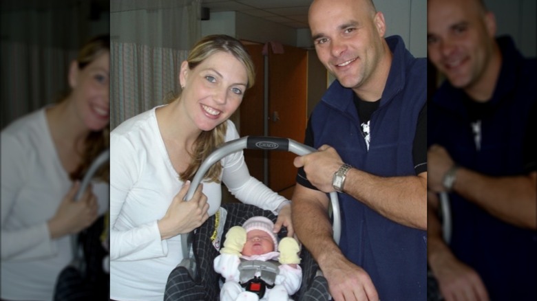 Bryan and Sarah Baeumler smiling while holding Charlotte Baeumler