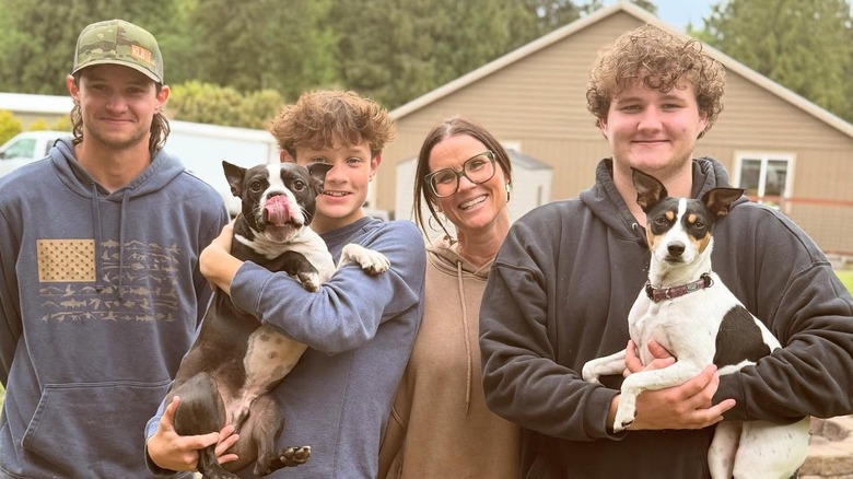 Leslie Davis posing with her kids and dogs outdoors.